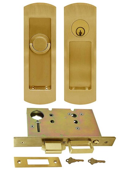 Premium Keyed Pocket-Door Mortise Lock Set with Rounded Pulls in Aged Brass.